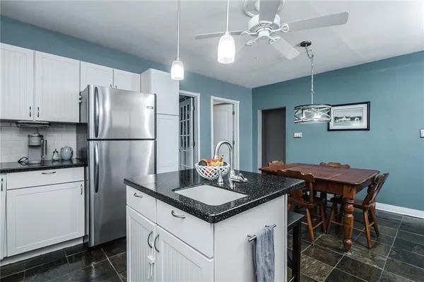 a kitchen with granite countertop white cabinets and a sink