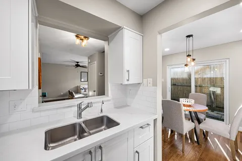 a kitchen with a sink chairs and a refrigerator