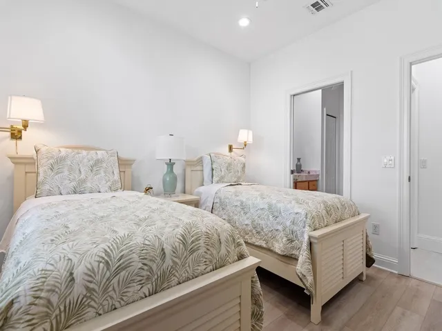 a bedroom with two beds and lamp