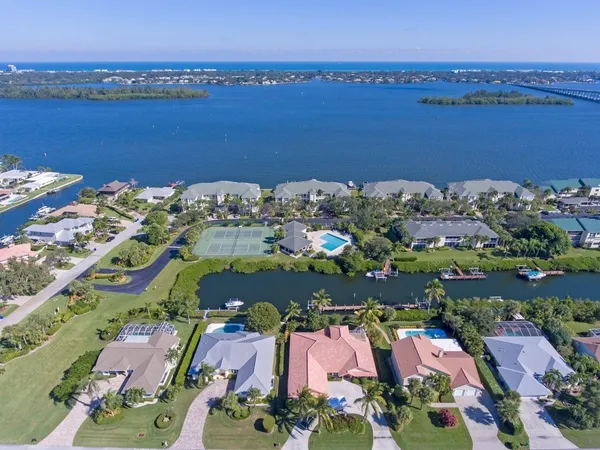 an aerial view of ocean and residential houses with outdoor space