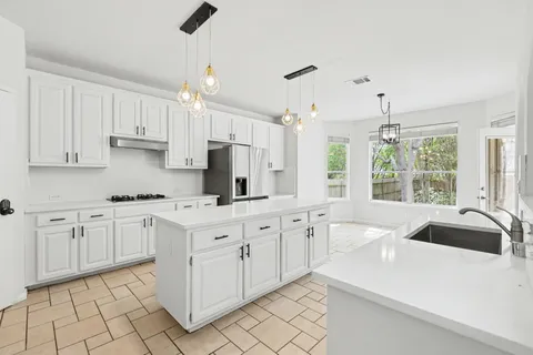 a kitchen with granite countertop white cabinets white appliances with a sink and dishwasher