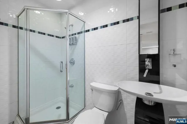 a bathroom with a shower a toilet and sink