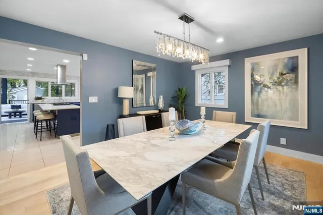 a dining room with wooden floor a chandelier a wooden table and chairs