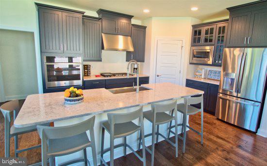 19209 Cavendish Way Lewes, DE 19958 - Photo 2 of 6 a kitchen with stainless steel appliances granite countertop a dining table chairs and refrigerator