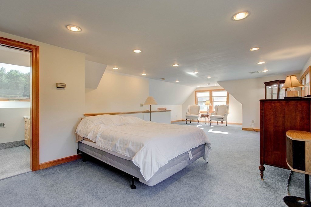 51 Green Road Bolton, MA 01740 - Photo 8 of 25 a spacious bedroom with a bed and a table in it
