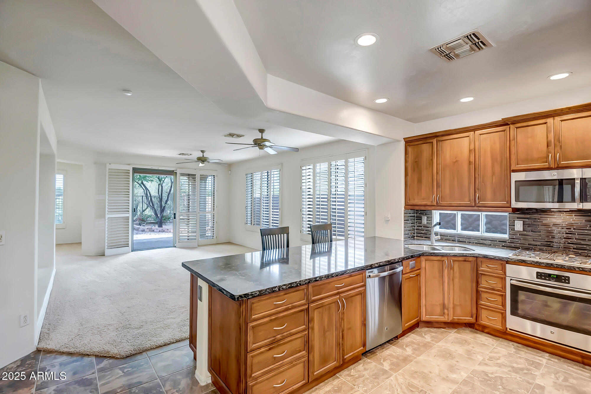 41628 North Cedar Chase Road Anthem, AZ 85086 - Photo 7 of 36 a large kitchen with granite countertop a large counter top space a sink stainless steel appliances and cabinets