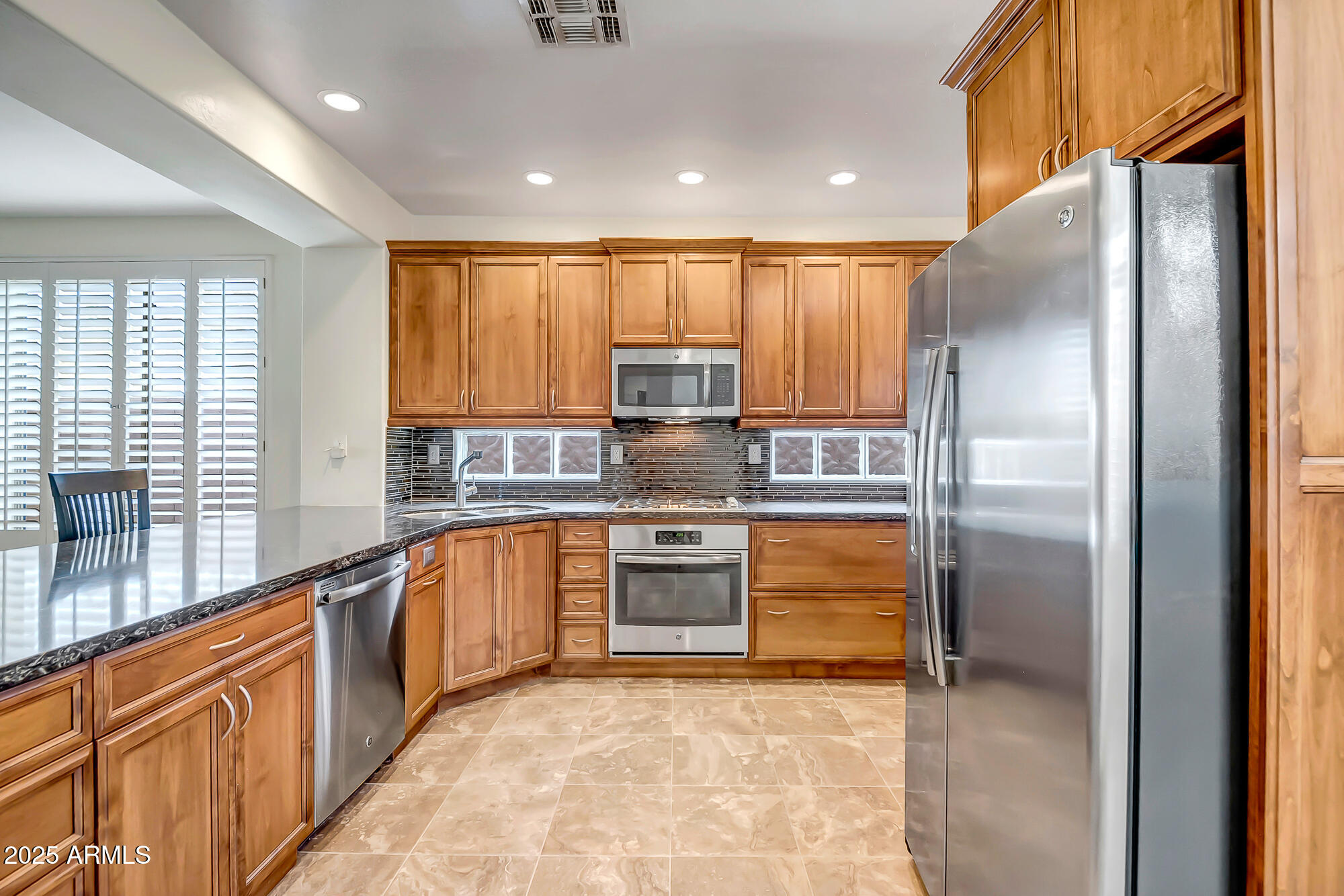 41628 North Cedar Chase Road Anthem, AZ 85086 - Photo 9 of 36 a modern kitchen with stainless steel appliances granite countertop a refrigerator and a sink