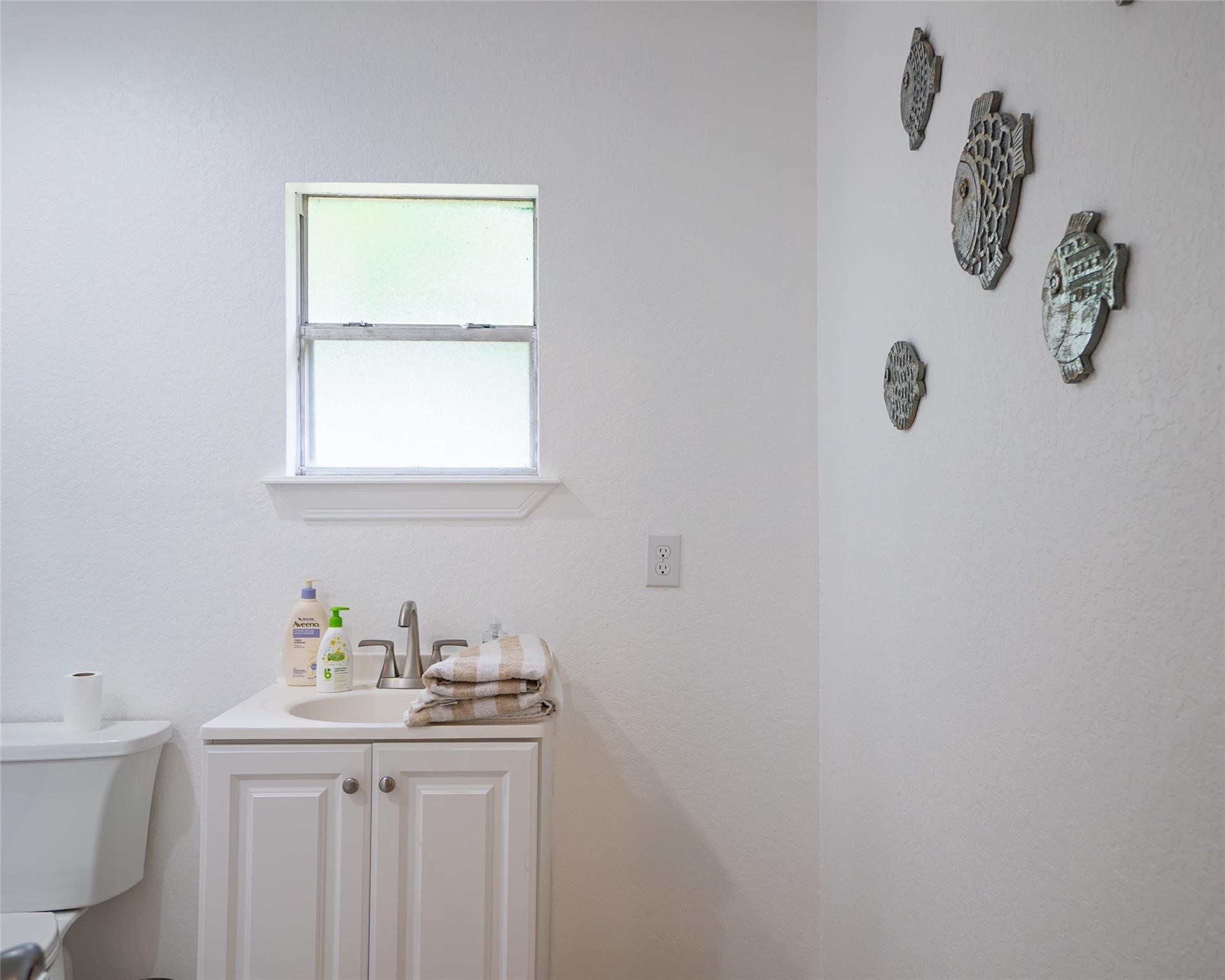 357 County Road 296 Sargent, TX 77414 - Photo 17 of 22 a bathroom with a granite countertop sink a toilet and with mirror