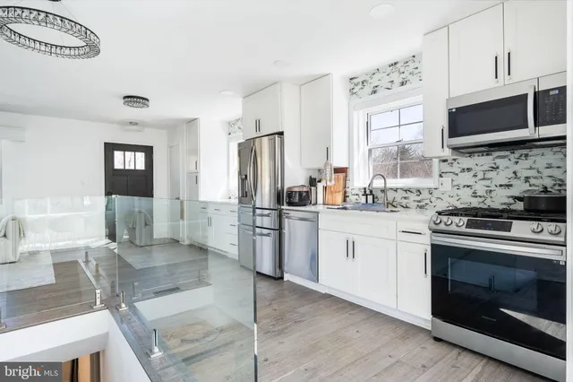 a kitchen with stainless steel appliances kitchen island granite countertop a stove a sink and a microwave