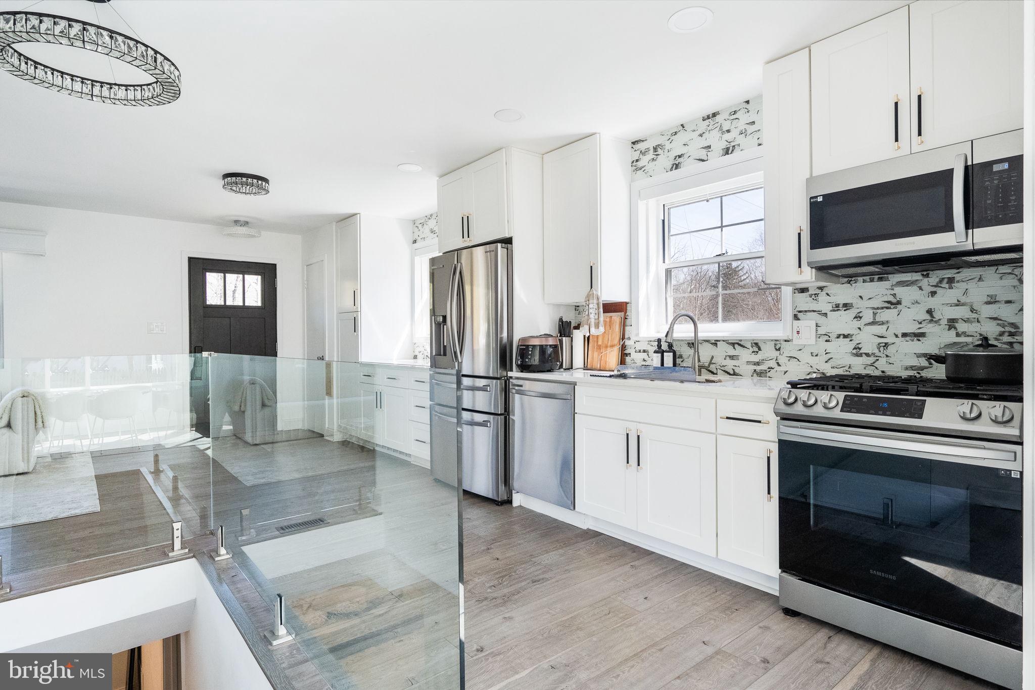 a kitchen with stainless steel appliances kitchen island granite countertop a stove a sink and a microwave