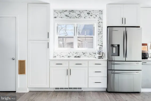 a kitchen with granite countertop white cabinets and white appliances