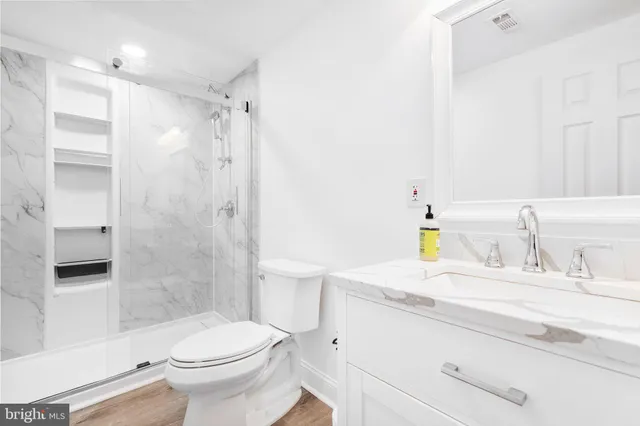 a bathroom with a sink a toilet and shower