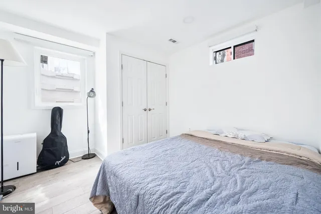 a bedroom with a bed and a painting on the wall