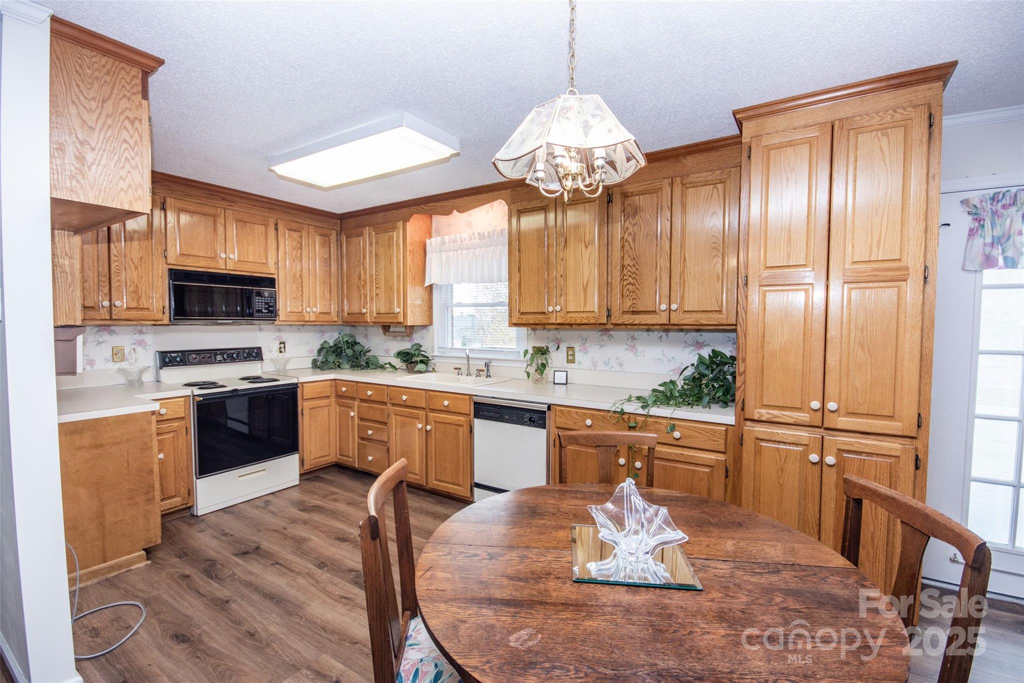 2890 Hobson Road Cleveland, NC 27013 - Photo 13 of 48 a kitchen with a chandelier stainless steel appliances cabinets and a counter top space