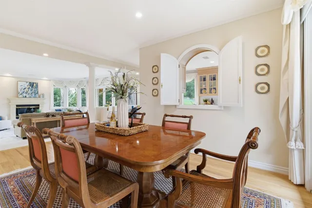 a view of a livingroom with furniture a fireplace wooden floor and windows