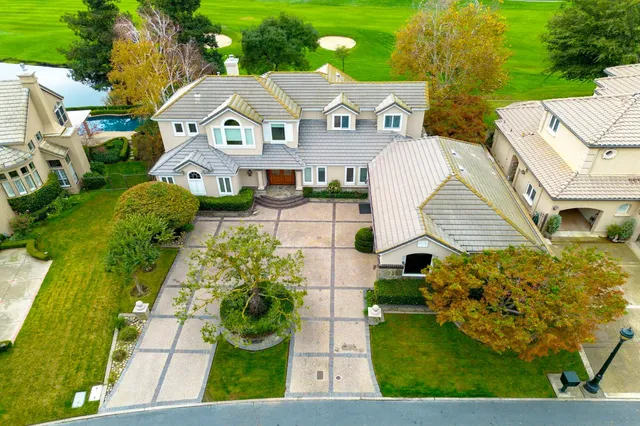 a view of a house with backyard and a tree