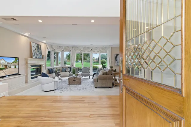 a living room with furniture a fireplace and a large window