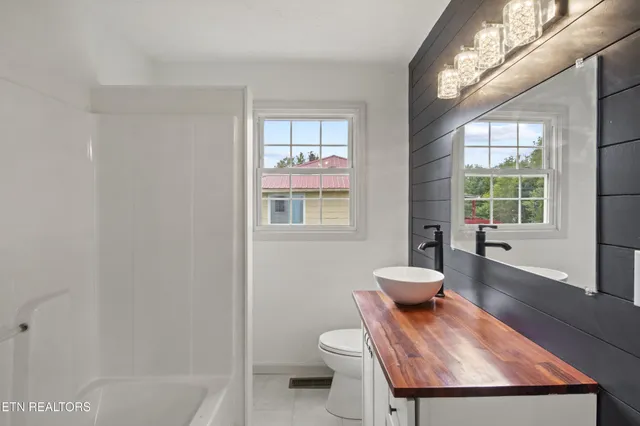 a bathroom with a toilet sink tub and window