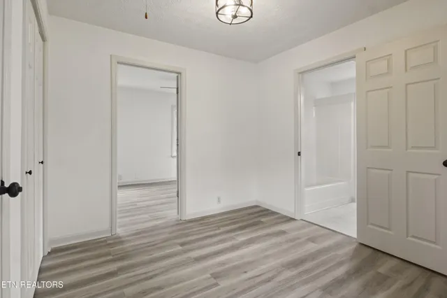an empty room with wooden floor and closet area