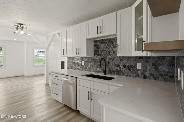 a kitchen with kitchen island granite countertop a sink cabinets and wooden floor