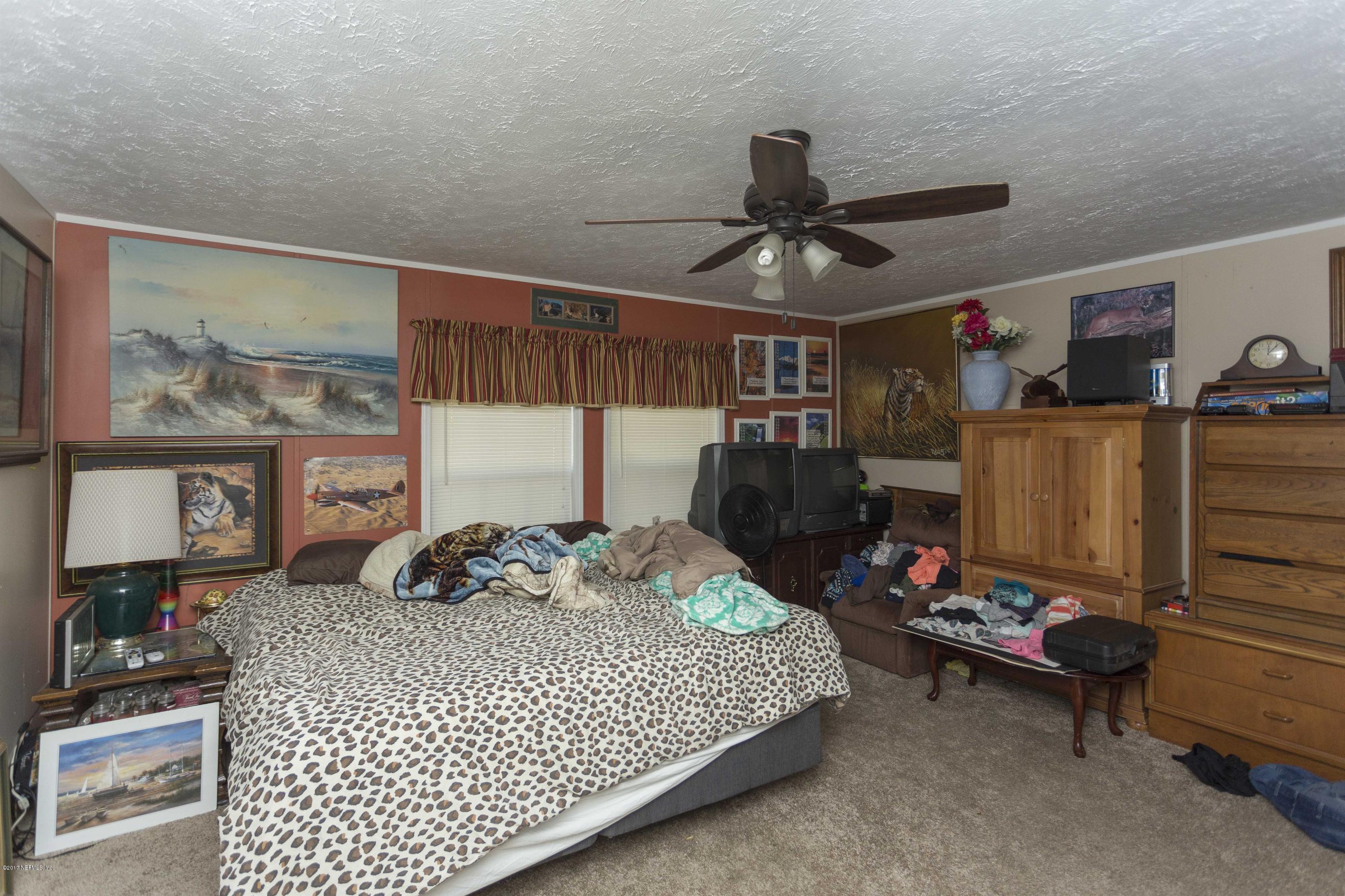 4049 Bronco Road Middleburg, FL 32068 - Photo 11 of 21 a bedroom with a bed and cabinets