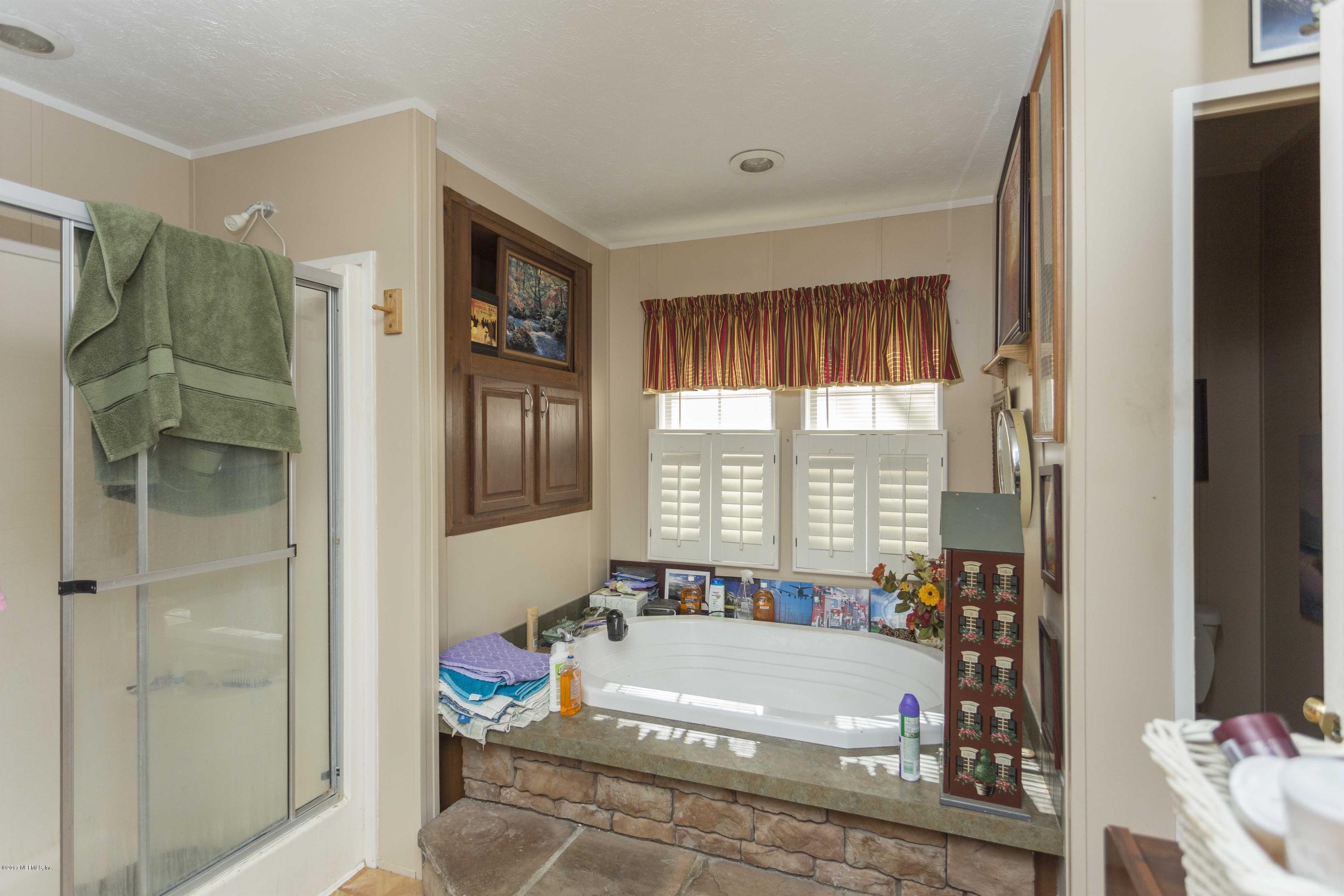 4049 Bronco Road Middleburg, FL 32068 - Photo 13 of 21 a bathroom with a tub and shower