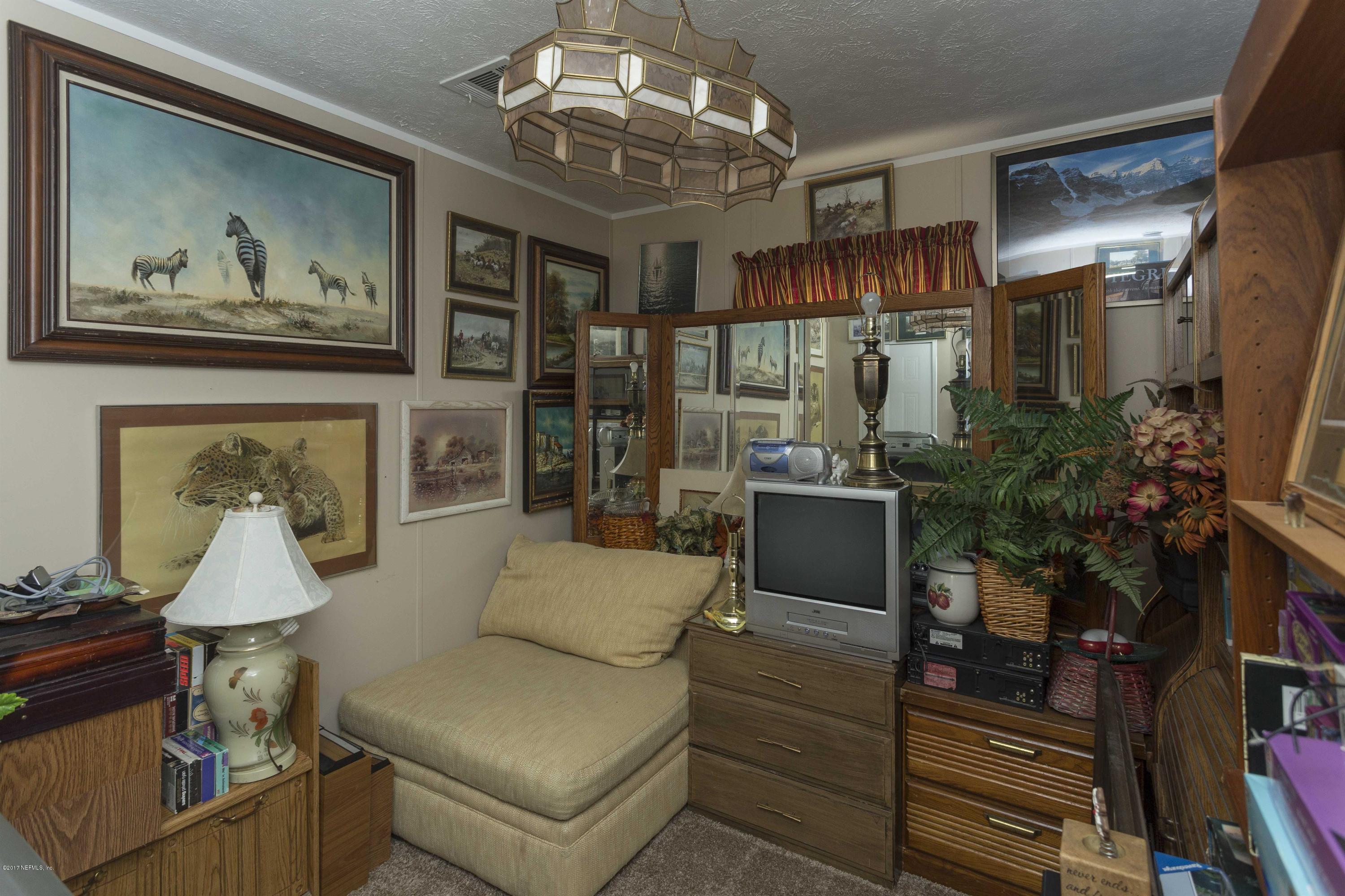 4049 Bronco Road Middleburg, FL 32068 - Photo 14 of 21 a living room with furniture and a chandelier