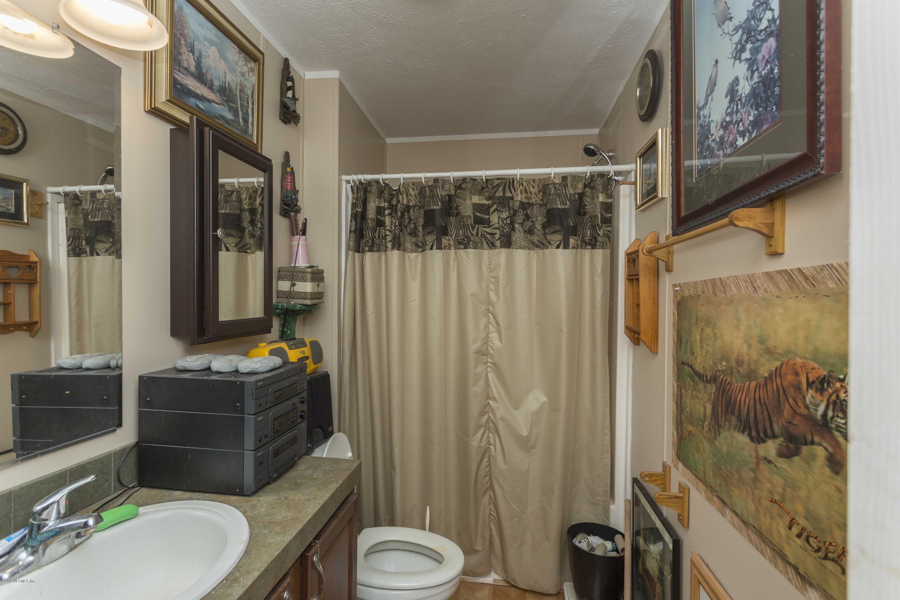 4049 Bronco Road Middleburg, FL 32068 - Photo 15 of 21 a bathroom with a sink a toilet and shower