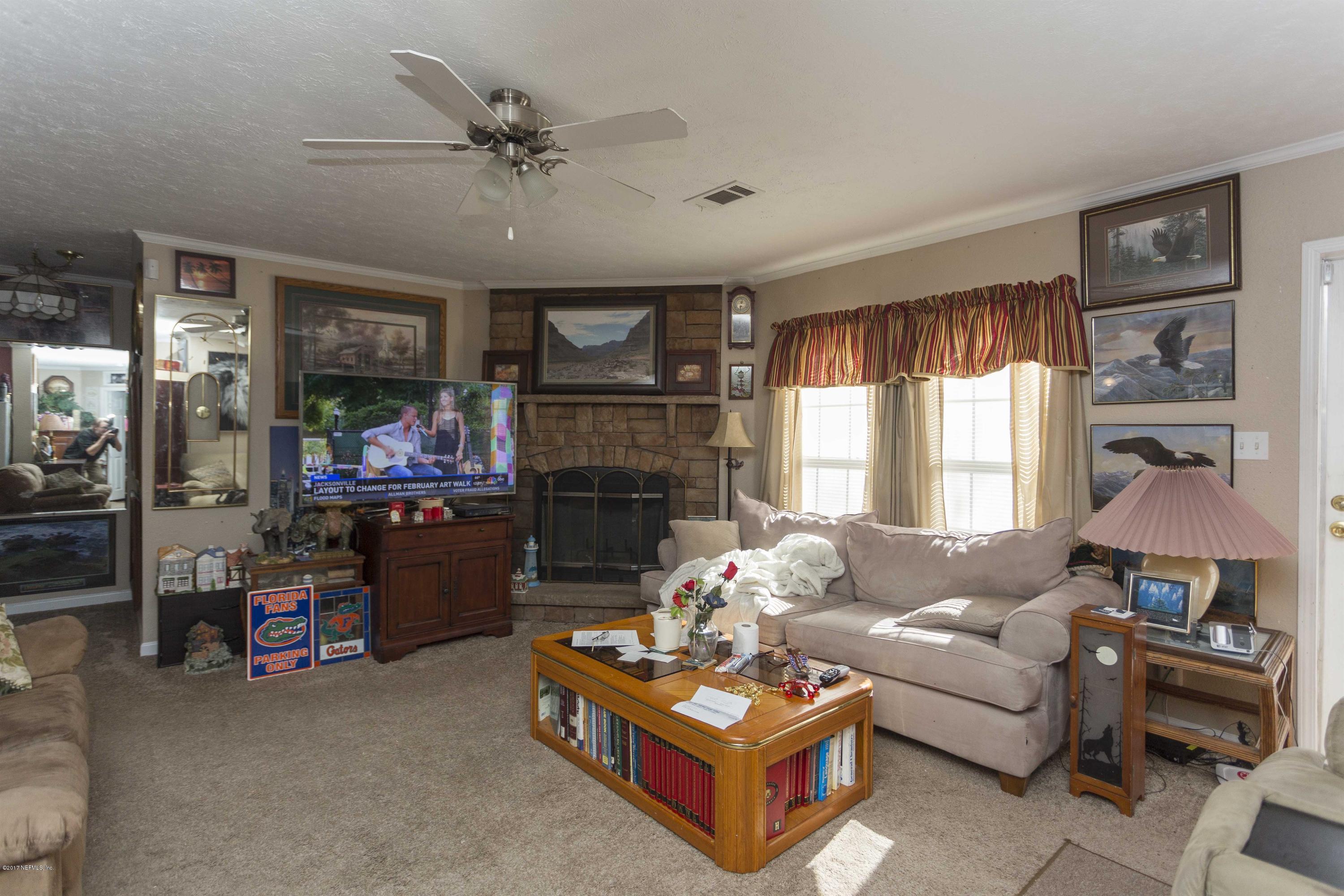 4049 Bronco Road Middleburg, FL 32068 - Photo 8 of 21 a living room with furniture and a fireplace