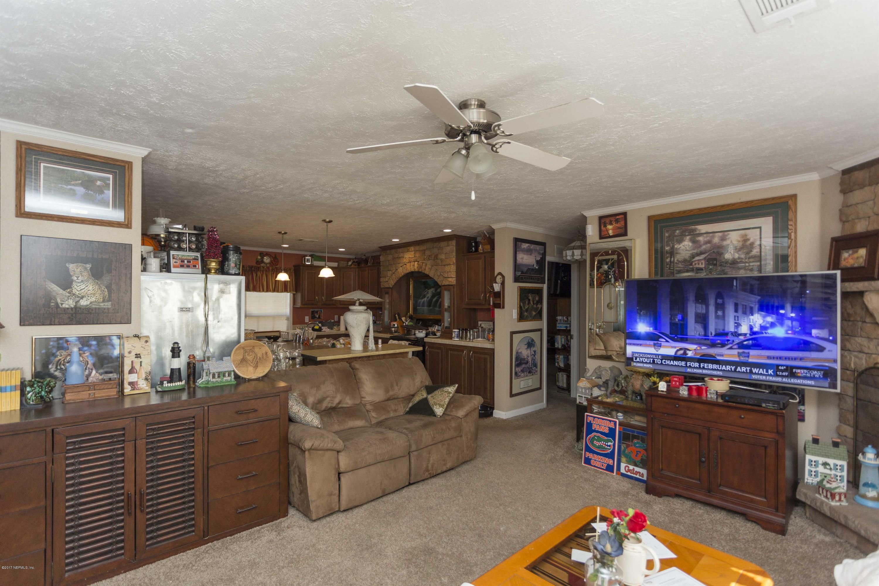 4049 Bronco Road Middleburg, FL 32068 - Photo 10 of 21 a living room with furniture a flat screen tv and kitchen view