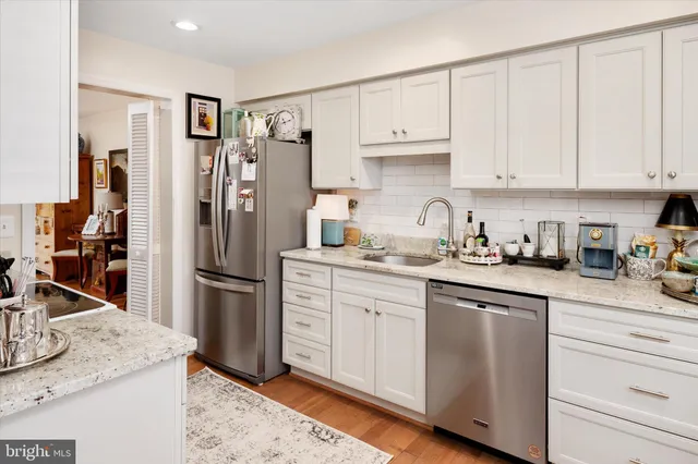 a kitchen with a sink a refrigerator and cabinets