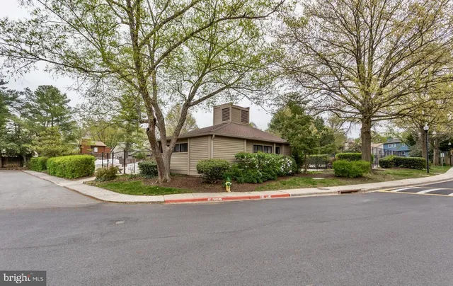 a front view of a house with a garden and trees