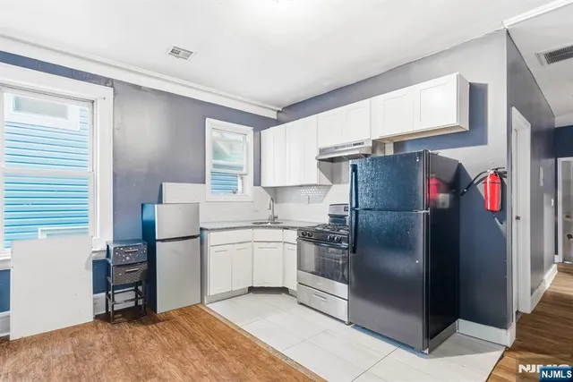 a kitchen with stainless steel appliances granite countertop a refrigerator and a stove