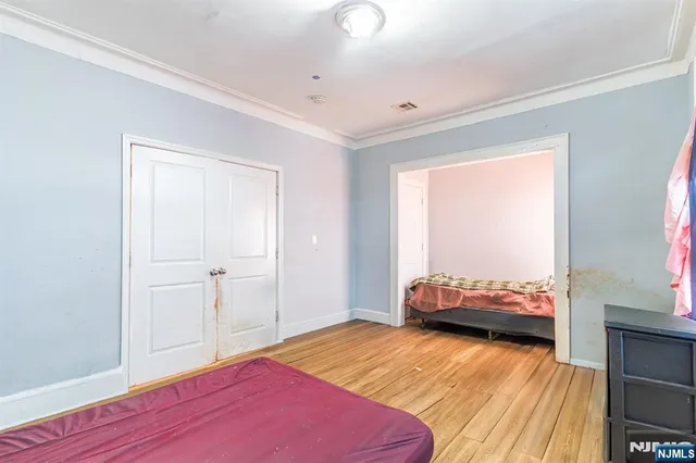 a bedroom with a bed and wooden floor