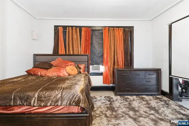 a bedroom with a large bed and wooden floor