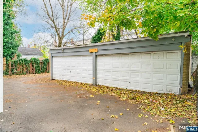 a view of a white house with a large windows and flower plants