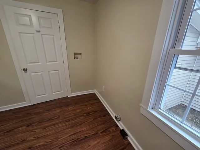 a view of a small space with wooden floor and a window