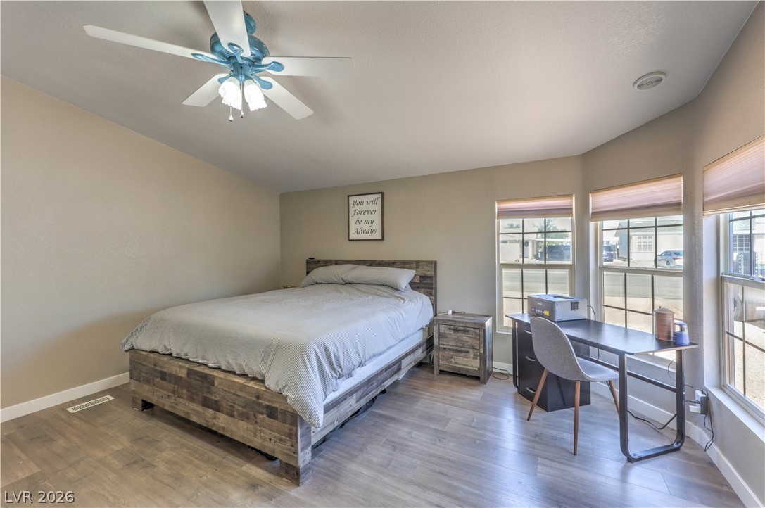 348 Tres Palomas Street Overton, NV 89040 - Photo 19 of 41 Well-lit sleeping quarters featuring elegant wood-style flooring and a functional ceiling fan for comfort.