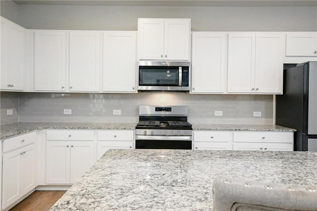 4774 Mock Orange Street Atlanta, GA 30331 - Photo 11 of 29 a kitchen with granite countertop white cabinets and stainless steel appliances