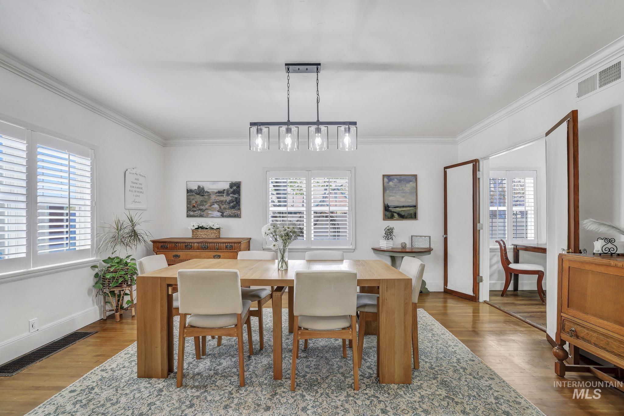 102 Fillmore Street Twin Falls, ID 83301 - Photo 13 of 48 Dining area featuring wood finished floors, healthy amount of natural light, and ornamental molding