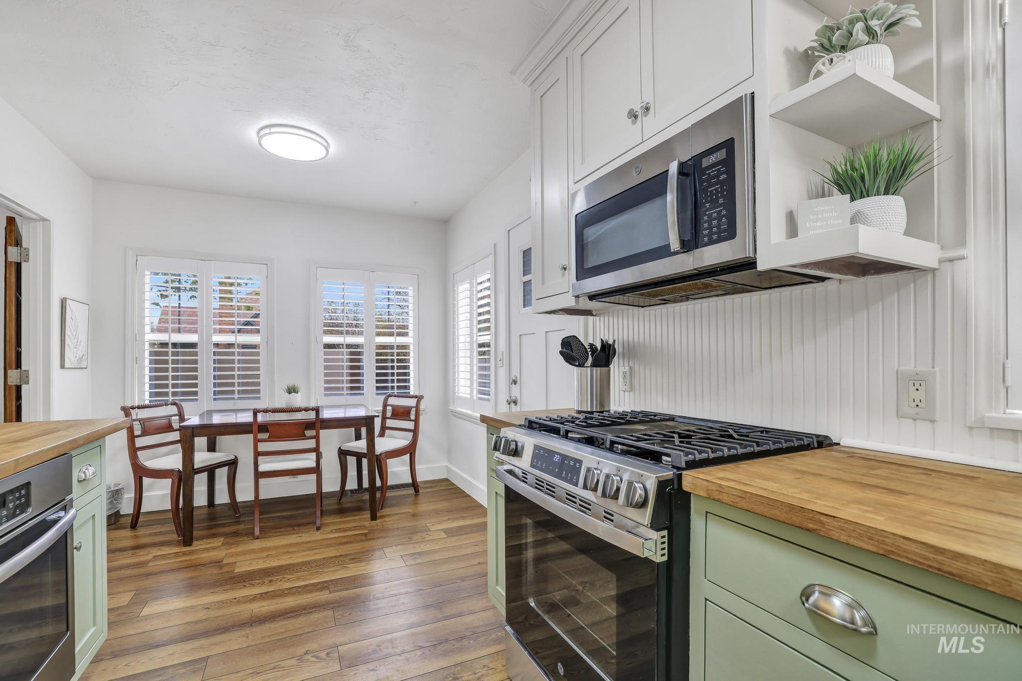 102 Fillmore Street Twin Falls, ID 83301 - Photo 17 of 48 Kitchen featuring green cabinetry, butcher block counters, stainless steel appliances, and open shelves