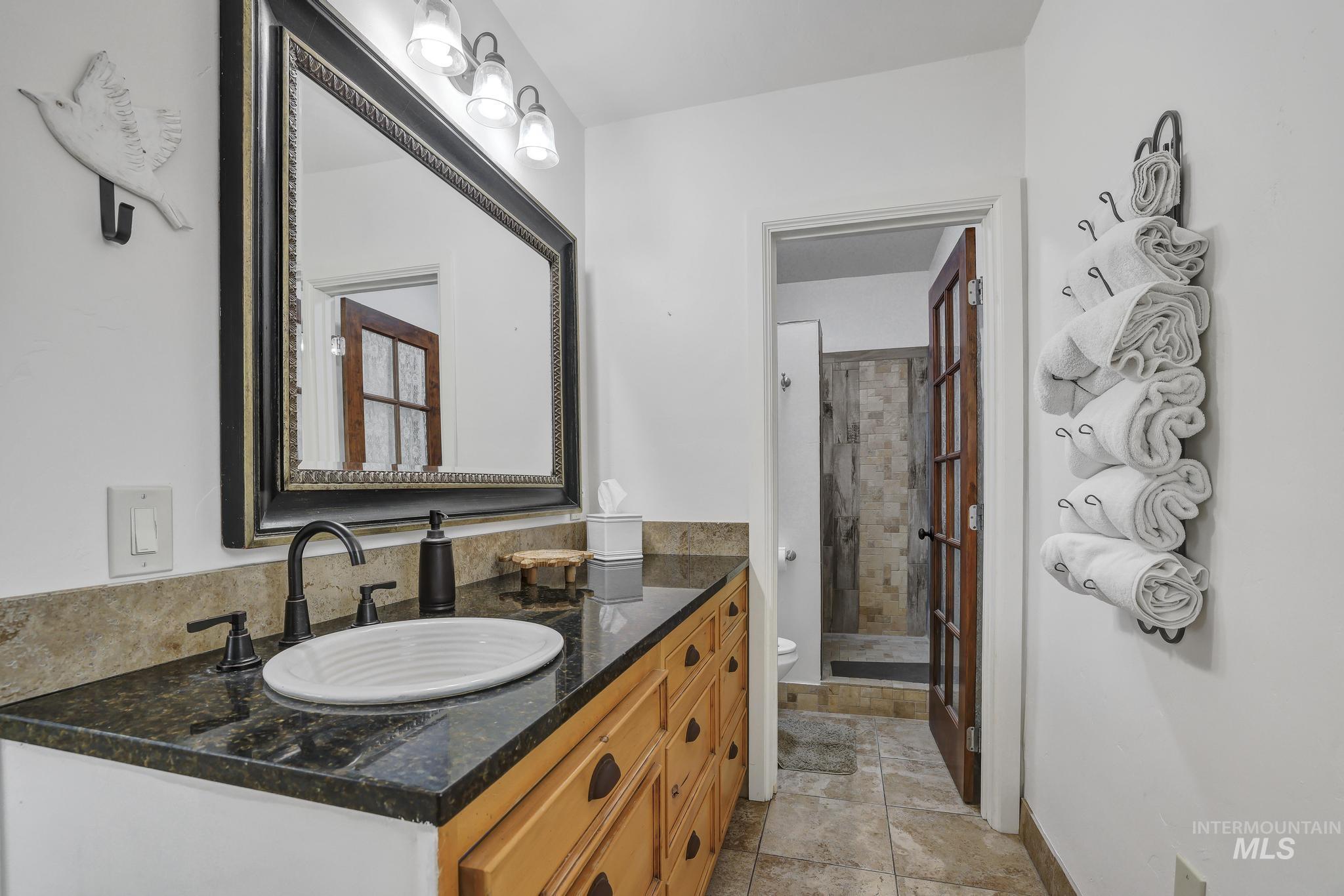 102 Fillmore Street Twin Falls, ID 83301 - Photo 25 of 48 Full bath with vanity, a stall shower, and light stone finish floors