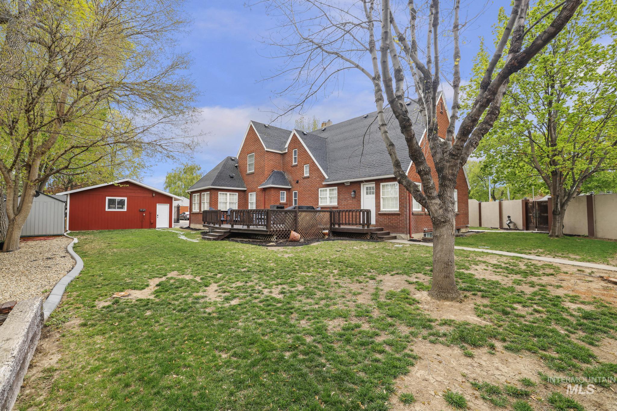 102 Fillmore Street Twin Falls, ID 83301 - Photo 42 of 48 Back of house with a deck, a shingled roof, brick siding, and a storage unit