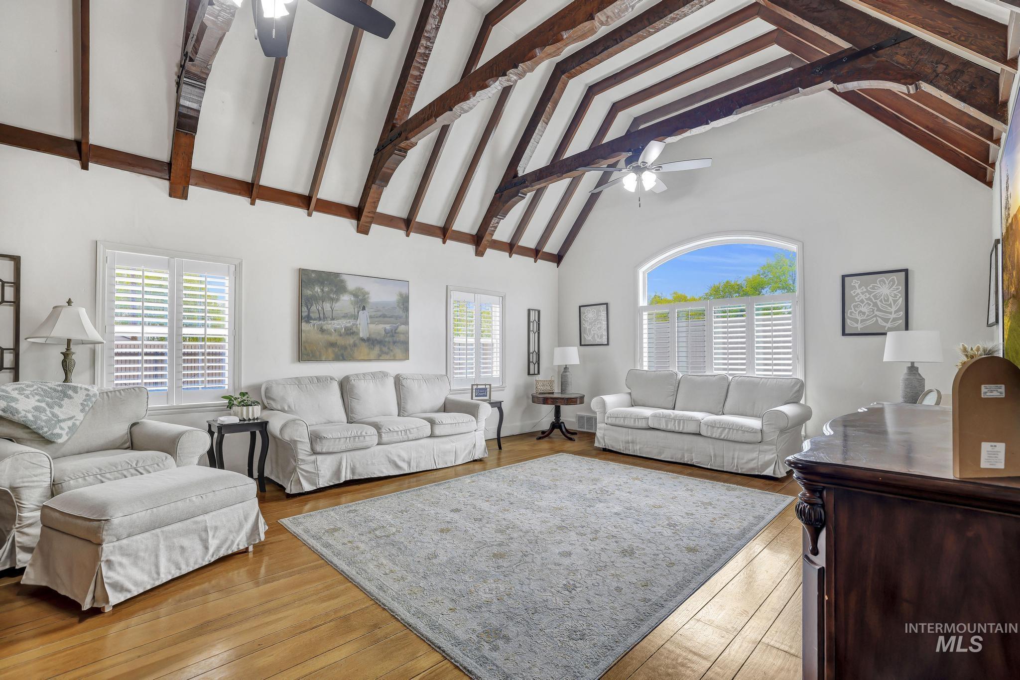 102 Fillmore Street Twin Falls, ID 83301 - Photo 10 of 48 Living room featuring ceiling fan, vaulted ceiling, light wood-style flooring, and healthy amount of natural light