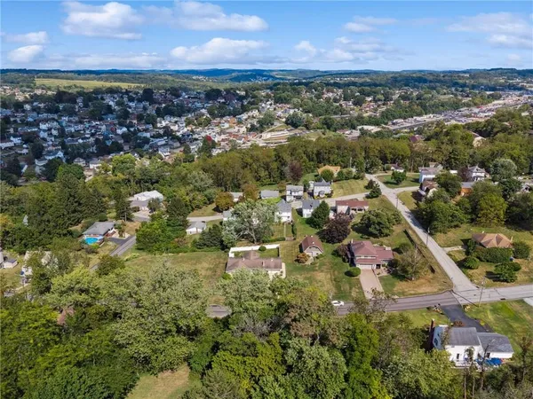 an aerial view of residential houses with outdoor space and trees