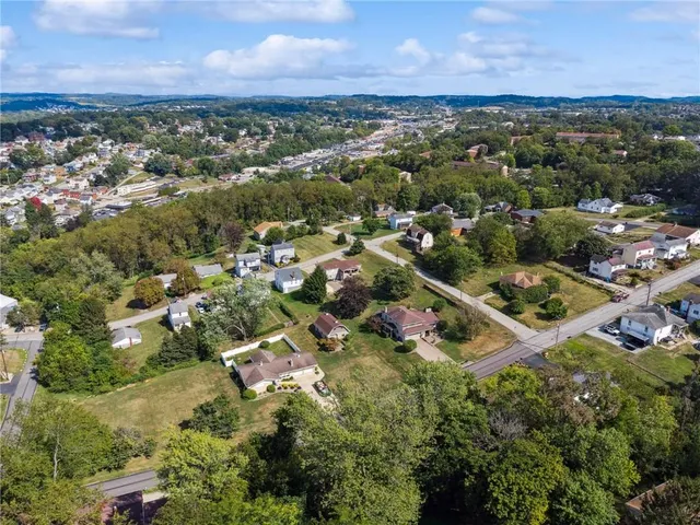 an aerial view of residential houses with outdoor space and trees
