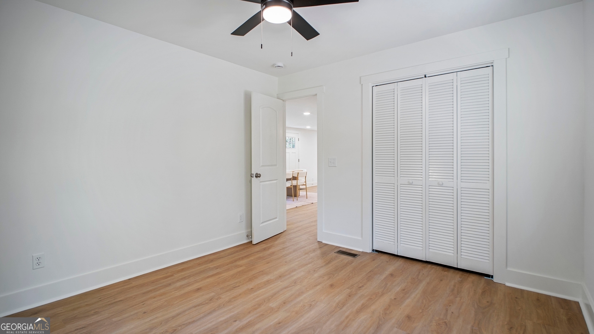 79 Terry Drive Midway, GA 31320 - Photo 18 of 27 an empty room with wooden floor a ceiling fan and windows