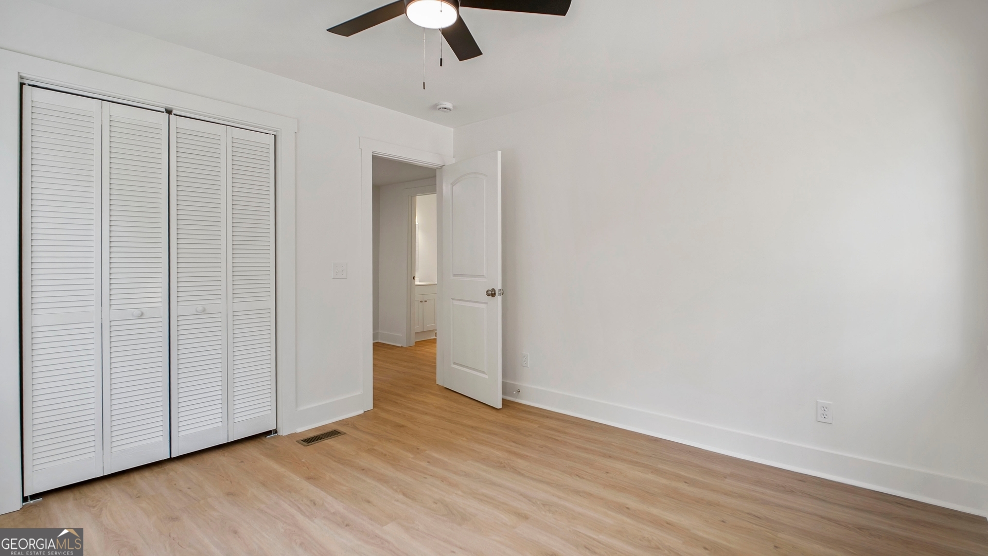79 Terry Drive Midway, GA 31320 - Photo 19 of 27 an empty room with wooden floor cabinet and a ceiling fan