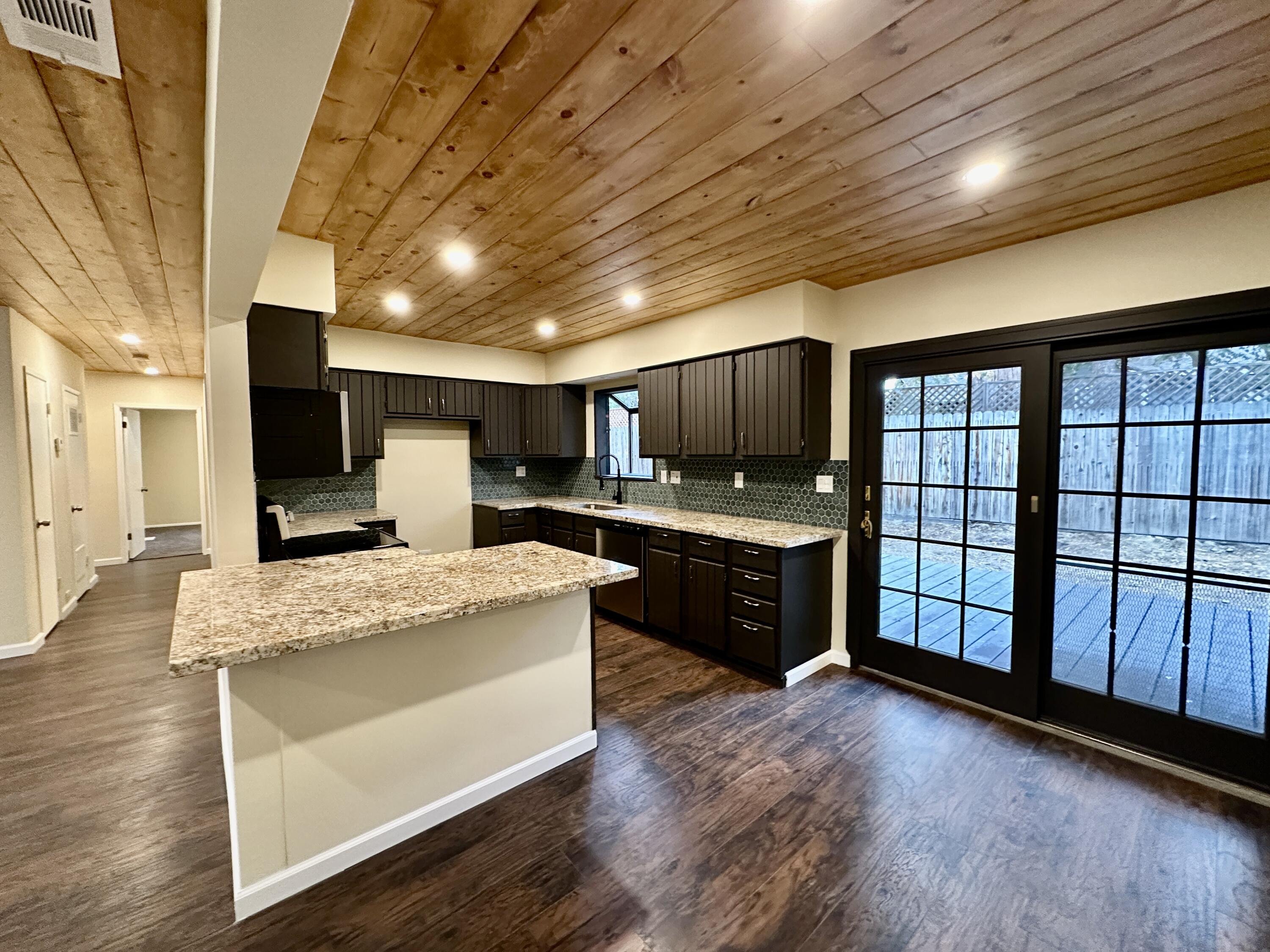 25340 Marion Ridge Drive Idyllwild, CA 92549 - Photo 6 of 31 a large white kitchen with kitchen island granite countertop wooden floors a stove and a sink