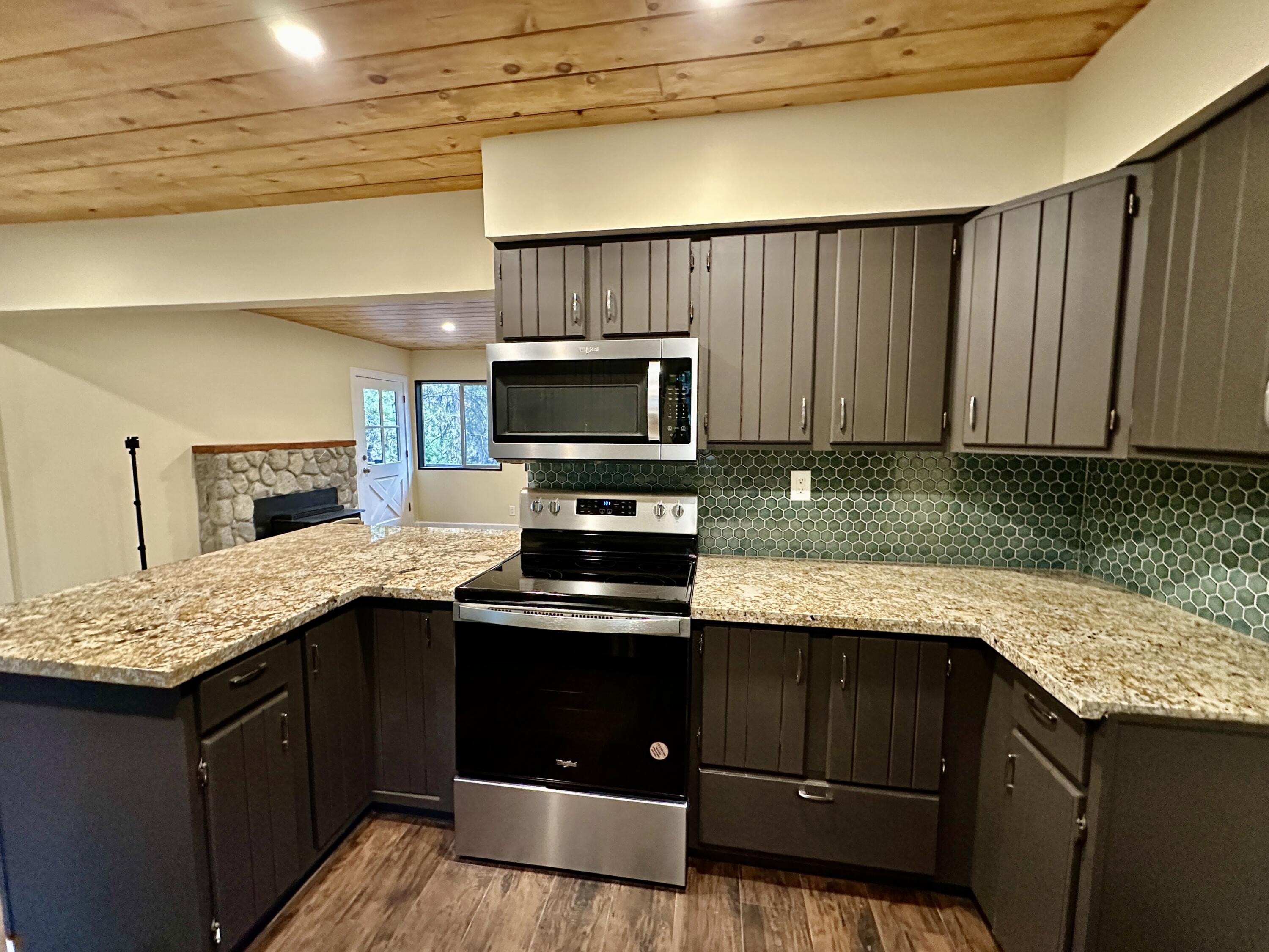 25340 Marion Ridge Drive Idyllwild, CA 92549 - Photo 9 of 31 a kitchen with stainless steel appliances granite countertop a stove a sink and a microwave